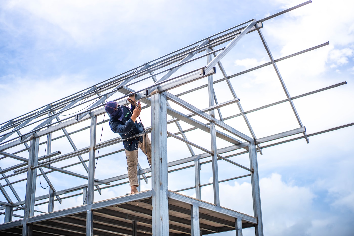 Technician welding a steel building frame